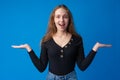 Smiling young woman pointing at copy space over blue background Royalty Free Stock Photo