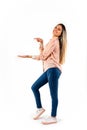 Smiling young woman pointing with one hand to the white space while with the other outstretched hand pretending to hold a product Royalty Free Stock Photo