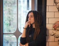 Smiling young woman portrait with dreadlocks posing near window