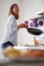 Smiling woman preparing eggs for breakfast in the bright morning in modern kitchen . Love, valentines day concept