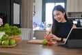 Smiling woman preparing healthy salad with fresh fruits and vegetable in the kitchen. Royalty Free Stock Photo