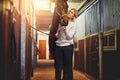 Young woman prepping her horse in stables before a ride Royalty Free Stock Photo