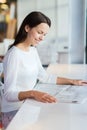 Smiling young woman reading newspaper at cafe Royalty Free Stock Photo