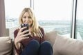 Smiling young woman reading text message at home Royalty Free Stock Photo