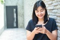 Smiling young woman reading text message or social media on cell telephone Royalty Free Stock Photo