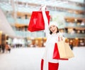 Smiling young woman with red shopping bags Royalty Free Stock Photo