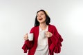 Smiling young woman in red sweater holding a white cup of coffee, standing over white background Royalty Free Stock Photo