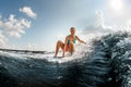 smiling young woman rides down the wave on a wakeboard Royalty Free Stock Photo