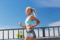 Smiling young woman running outdoors Royalty Free Stock Photo