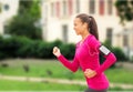 Smiling young woman running outdoors Royalty Free Stock Photo