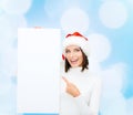 Smiling young woman in santa hat with white board Royalty Free Stock Photo