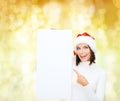 Smiling young woman in santa hat with white board Royalty Free Stock Photo