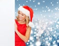 Smiling young woman in santa hat with white board Royalty Free Stock Photo