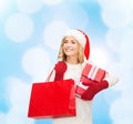 Smiling young woman in santa helper hat with gifts Royalty Free Stock Photo