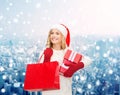 Smiling young woman in santa helper hat with gifts Royalty Free Stock Photo