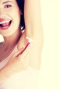 Smiling young woman shaving her armpit Royalty Free Stock Photo