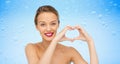 Smiling young woman showing heart shape hand sign Royalty Free Stock Photo