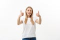 Smiling young woman showing thumbs up and looking at the camera over white background Royalty Free Stock Photo