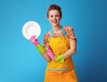 Smiling young woman showing washed plate on blue