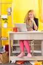 Smiling young woman sit at desk work on laptop or watching webinar making notes in notebook Royalty Free Stock Photo