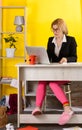 Smiling young woman sit at desk work on laptop or watching webinar making notes in notebook Royalty Free Stock Photo