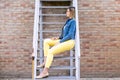 smiling young woman sits on stairs. urban scene Royalty Free Stock Photo