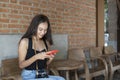 Young woman sitting on  bench and using smart phone. Royalty Free Stock Photo