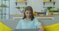 Smiling young woman sitting on couch using laptop notebook looking at screen typing message, happy lady chatting on Royalty Free Stock Photo