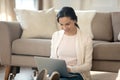 Smiling young woman sitting on floor, using computer. Royalty Free Stock Photo