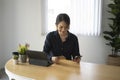 Young woman sitting in front of tablet computer using smart phone and holding credit card for online online shopping. Royalty Free Stock Photo