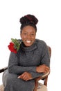 Smiling young woman sitting with a red rose Royalty Free Stock Photo