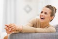 Smiling young woman sitting on sofa Royalty Free Stock Photo