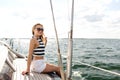 Smiling young woman sitting on yacht deck