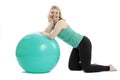 Smiling young woman in sportswear doing exercises with fitness ball. Isolated over white background Royalty Free Stock Photo