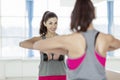 Smiling young woman in sportswear with dumbbells in front of a mirror in the gym Royalty Free Stock Photo