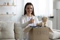 Smiling young woman stack clothes in box recommend donating