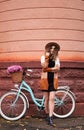 Smiling young woman standing near blue bicycle in city. Royalty Free Stock Photo