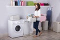 Woman Standing Near Washing Machine With Basket Of Clothes Royalty Free Stock Photo