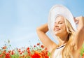 Smiling young woman in straw hat on poppy field Royalty Free Stock Photo