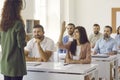 Happy woman raises her hand to ask the teacher a question during a training or seminar Royalty Free Stock Photo