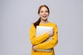 Smiling young woman student holding laptop computer and looking at camera on isolated background. Royalty Free Stock Photo