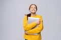 Smiling young woman student holding laptop computer and looking at camera on isolated background. Royalty Free Stock Photo