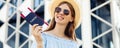 Smiling young woman in summer hat and glasses, traveler with passport in hands and plane tickets, outdoors, concept of travel