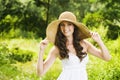 Smiling young woman in sun hat against background of summer green park. Beautiful healthy happy girl enjoying freedom outside Royalty Free Stock Photo