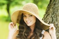 Smiling young woman in sun hat against background of summer green park. Beautiful healthy happy girl enjoying freedom Royalty Free Stock Photo