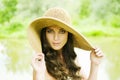 Smiling young woman in sun hat against background of summer green park. Beautiful healthy happy girl enjoying freedom Royalty Free Stock Photo