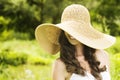 Smiling young woman in sun hat against background of summer green park covering her eyes. Beautiful healthy happy girl Royalty Free Stock Photo