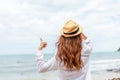 Smiling young woman in sun hat and finger thumb up on beach. summer, holidays, vacation, travel concept Royalty Free Stock Photo