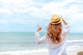 Smiling young woman in sun hat and finger thumb up on beach. summer, holidays, vacation, travel concept Royalty Free Stock Photo