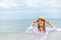 Smiling young woman in sun hat and waring sun glasses on the  beach. summer, holidays, vacation, travel concept Royalty Free Stock Photo